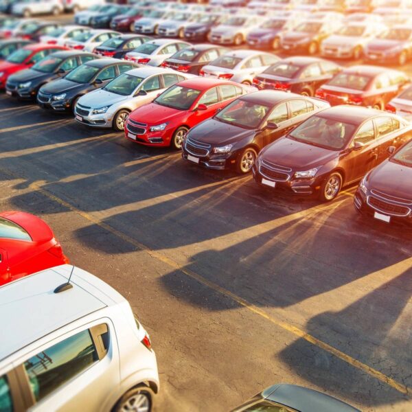 A parking lot filled with lots of cars parked in rows.