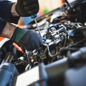 A person working on an engine in the process of fixing it.