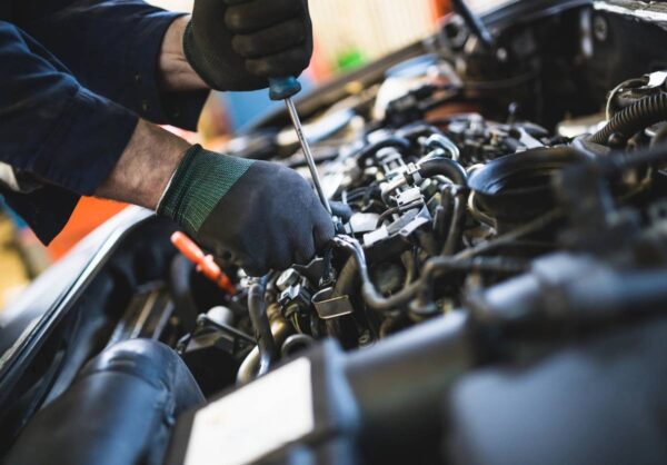 A person working on an engine in the process of fixing it.