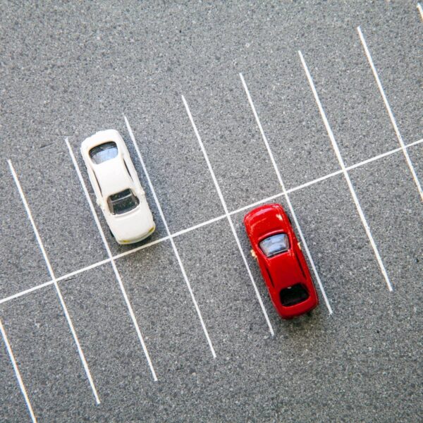 Two cars are parked in a parking lot.