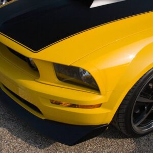 A close up of the front end of a yellow car