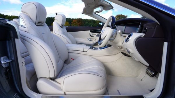 A car with white leather seats and a steering wheel.