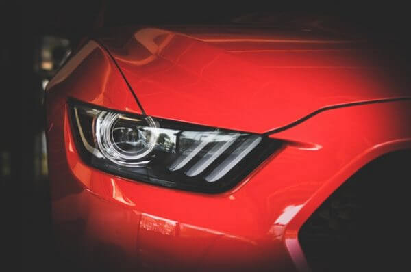 A close up of the headlight on a red car